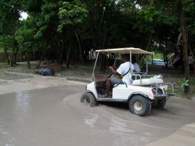 golf cart drives through flooded street during the rainy season Ambergris Caye, Belize – Best Places In The World To Retire – International Living